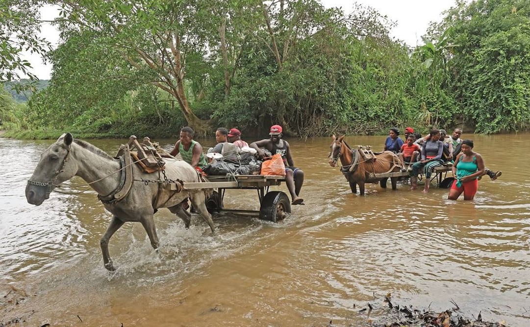 Migrantes haitianos cruzan el río Guatí, en Acandí, Colombia, en su camino al Tapón del Darién. El Cártel de Sinaloa está implicado en el tráfico de personas. Fotos: Mauricio Dueñas/ EFE.