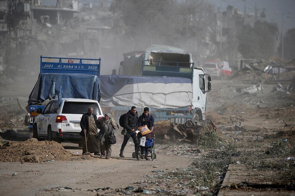 Palestinos cruzan desde el norte de la Franja de Gaza hacia el sur de la Franja de Gaza mientras tanques israelíes (no en la foto) avanzan por la carretera de Salah Al Din, en el centro de la Franja de Gaza. FOTO: MOHAMMED SABER. EFE