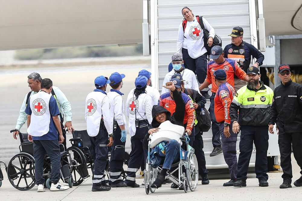Un migrante venezolano hace un gesto de aprobación con el pulgar mientras es trasladado en silla de ruedas a su llegada al Aeropuerto Internacional Simón Bolívar en Maiquetía, Venezuela, el 20 de marzo de 2025.  Foto: AFP