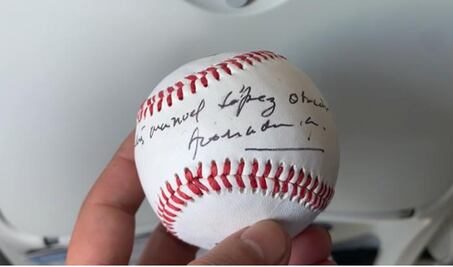 AMLO autografía pelota de beisbol a tripulación de su vuelo