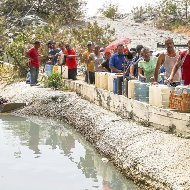 Ciudadanos buscan agua en una construcción abandonada, en Caracas. MIGUEL GUTIÉRREZ. EFE