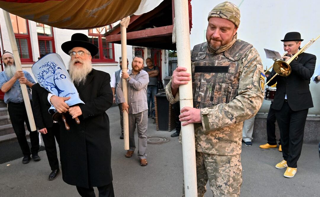 Un militar judío ucraniano participa en la procesión mientras el Gran Rabino de Kiev y Ucrania Yaakov Dov Bleich lleva un nuevo Suvoy (rollo) de la Torá en memoria de los soldados ucranianos caídos durante su ceremonia de inauguración en la sinagoga de Kiev, el 22 de septiembre de 2023. Foto: AFP