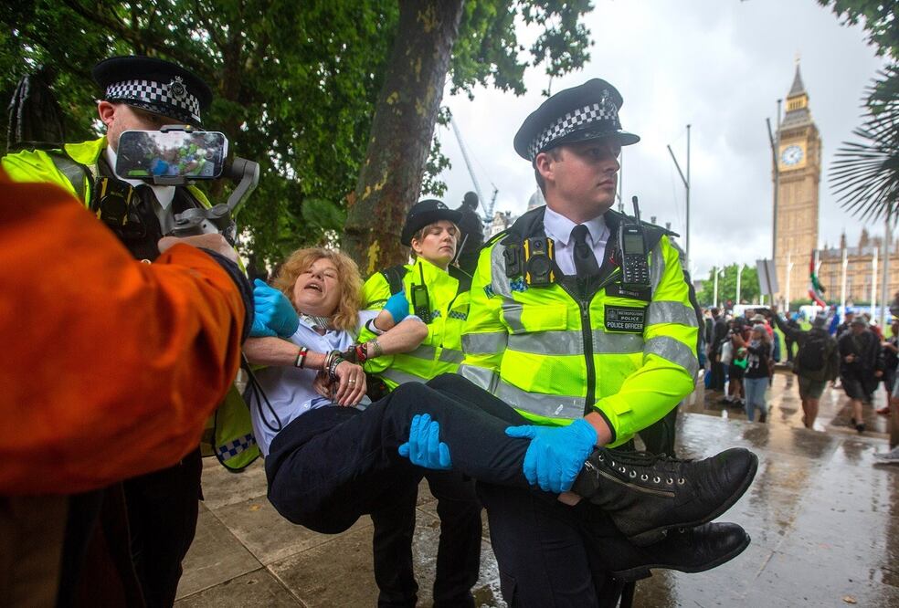 Policías detienen a una manifestante que llevaba una pancarta en apoyo del grupo Palestine Action group, en Londres. FOTO: EFE