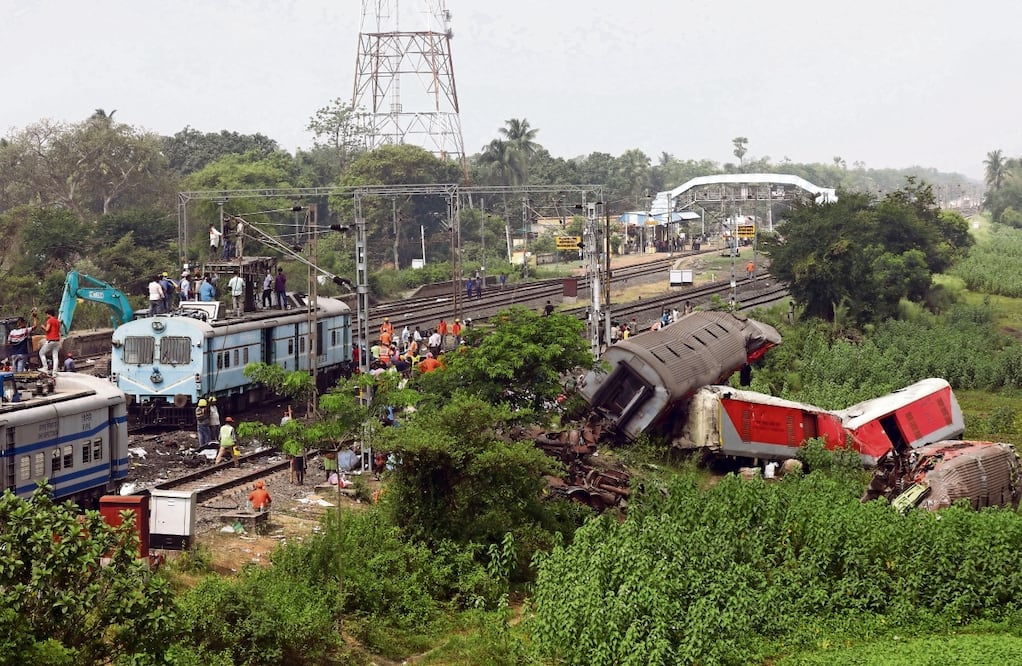 Trabajadores remueven escombros en la zona donde chocaron los trenes, en Odisha, India.
