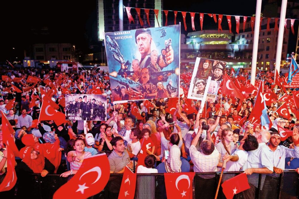 Simpatizantes del mandatario Recep Tayyip Erdogan muestran pancartas con la imagen de él y ondean banderas, durante un mitin ayer en Estambul (OSMAN ORSAL. REUTERS)