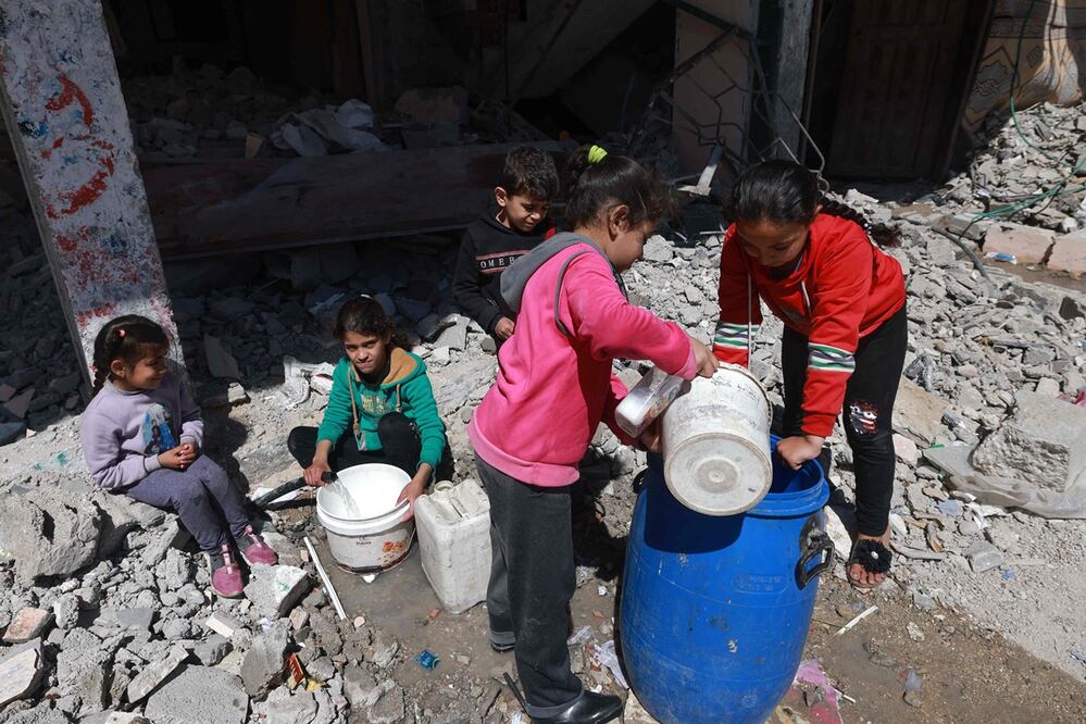 Niños palestinos van a buscar agua en Rafah, en el sur de la Franja de Gaza, el 15 de marzo de 2024, en medio de batallas en curso entre Israel y el grupo militante Hamas. Foto: AFP