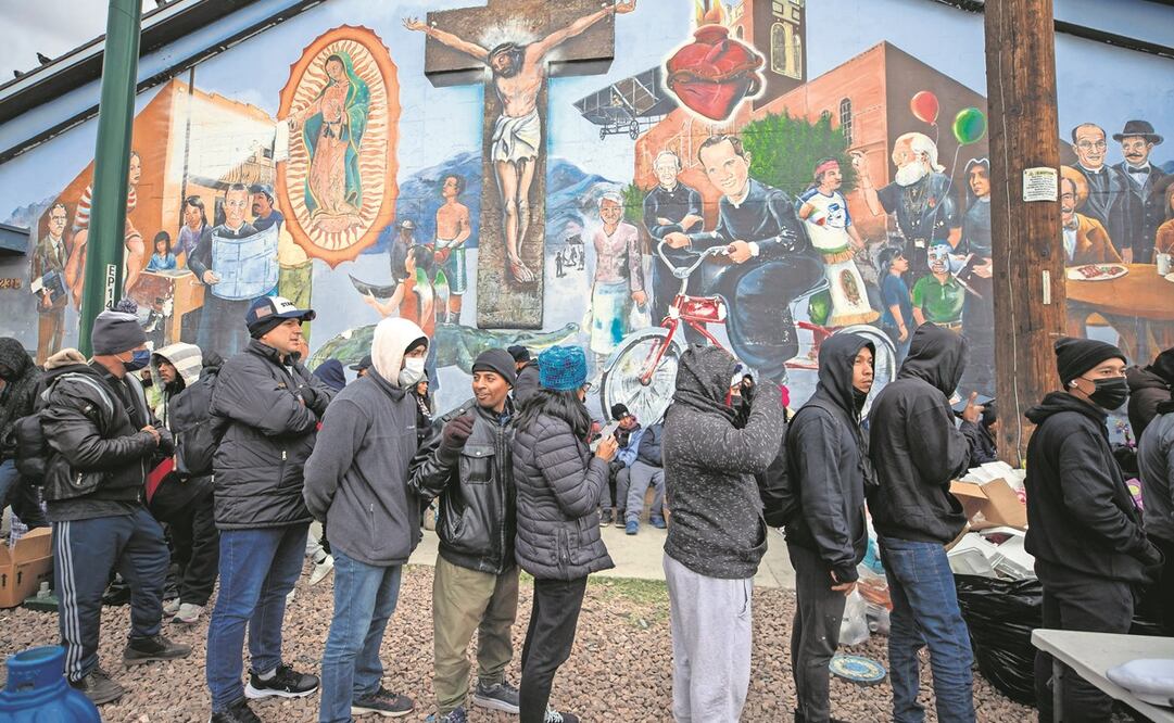 Los migrantes forman una fila para recibir alimentos donados por los residentes en el centro de El Paso, Texas. Foto: Andres Leighton / AP