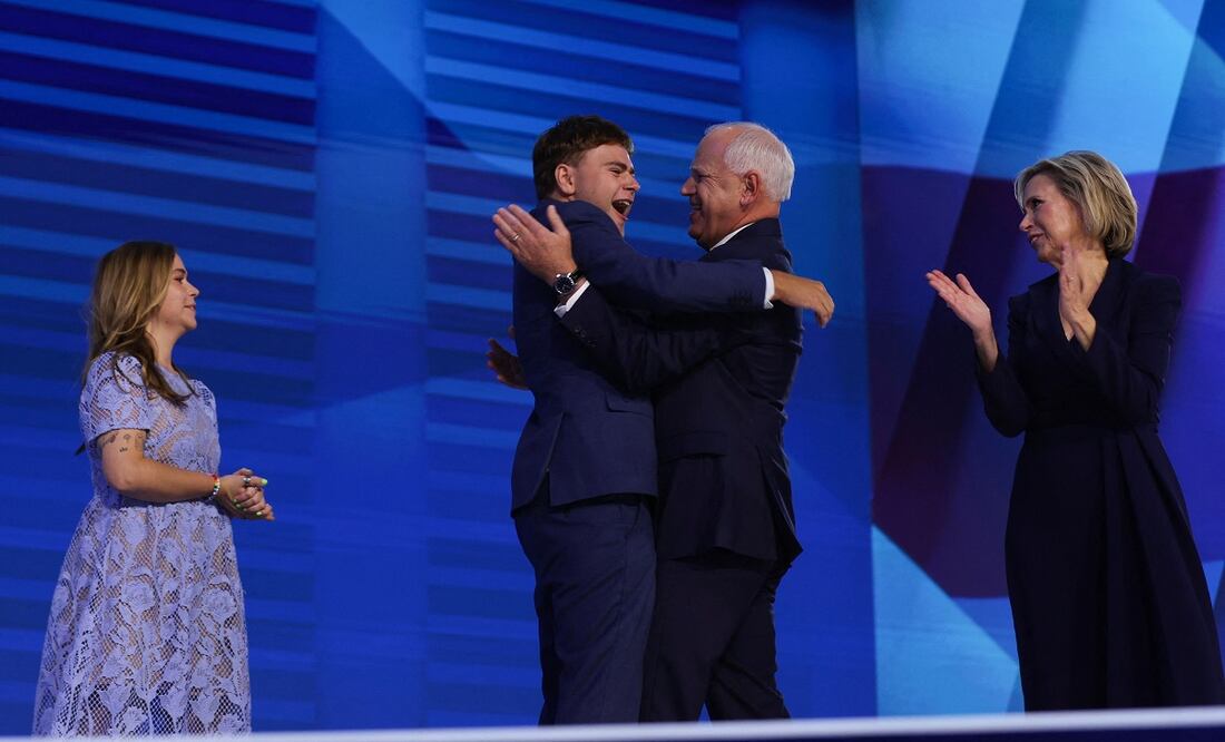 Gus abraza a su padre, el candidato vicepresidencial demócrata Tim Walz, al término de su discurso de aceptación. FOTO: AFP