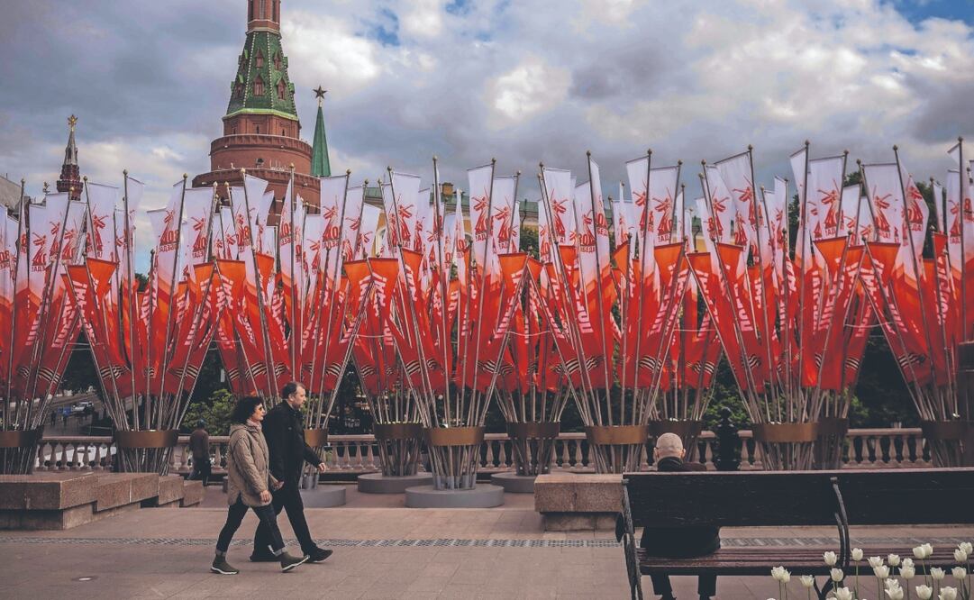 Una pareja en la céntrica plaza Manezhnaya de Moscú, decorada para las celebraciones del Día de la Victoria, que conmemora el 80 aniversario de la victoria de la Unión Soviética sobre la Alemania nazi en la Segunda Guerra Mundial. Foto: de ANGELOS TZORTZINIS. AFP
