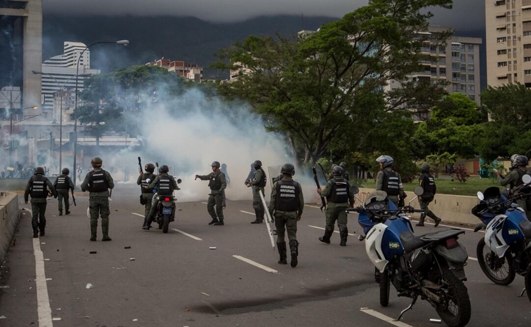 Miembros de la Guardia Nacional Bolivariana (GNB) se enfrentan con manifestantes de la oposición en las inmediaciones de la base aérea militar "Generalísimo Francisco de Miranda" (Foto: EFE)