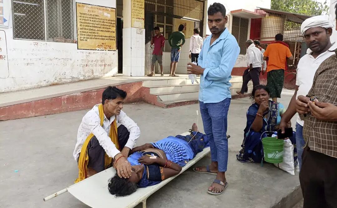 Familiares cuidan a un paciente acostado en una camilla afuera de un hospital del distrito de Ballia, en la India. Foto: AP