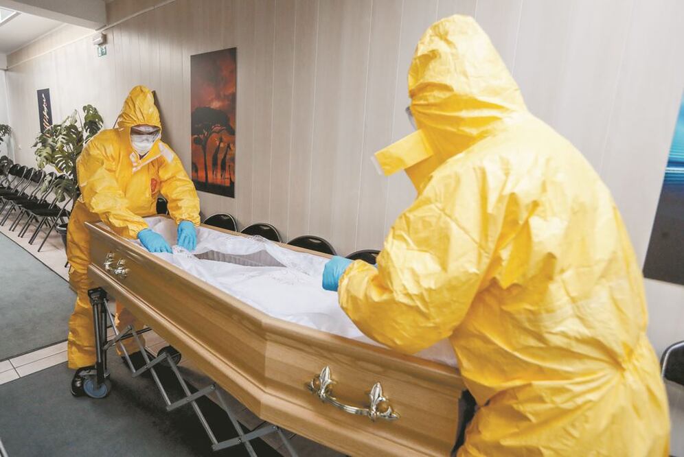 Empleados de una funeraria alistan el ataúd de una persona que falleció por coronavirus, en Bruselas, Bélgica. STEPHANIE LECOCQ. EFE