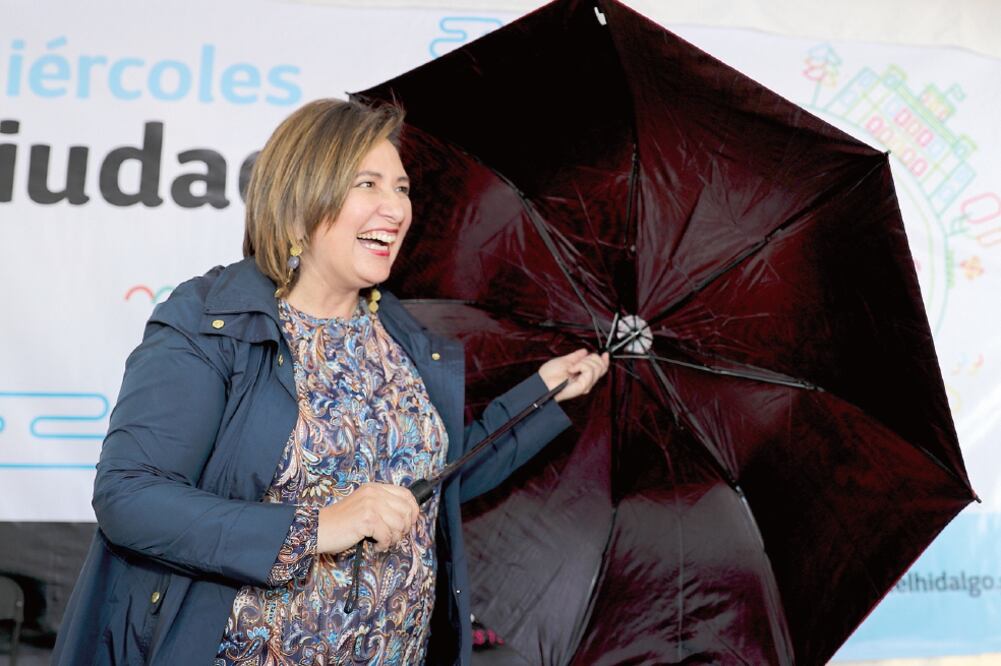 La delegada Xóchitl Gálvez cargó un paraguas para usarlo de escudo luego de que la amenazaron con lanzarle pañales sucios (GERMÁN GARCÍA. EL UNIVERSAL)