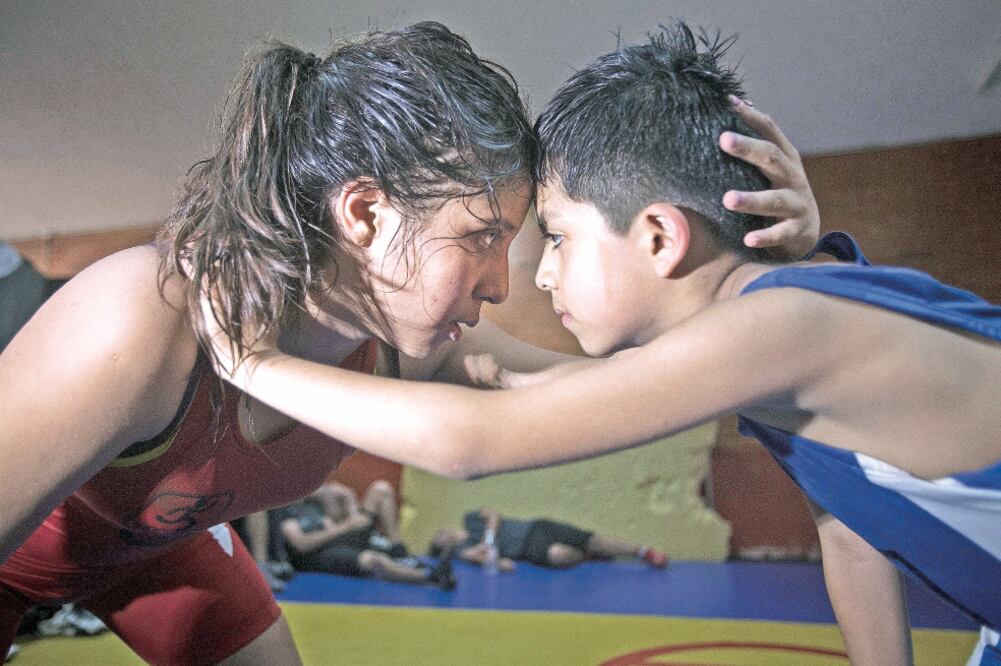 Ángel (derecha) lleva ocho meses entrenando la lucha. El deporte lo ha llevado a mejorar en aspectos de su vida diaria como su desempeño escolar, su físico, además de adquirir seguridad y confianza (JUAN CARLOS REYES)