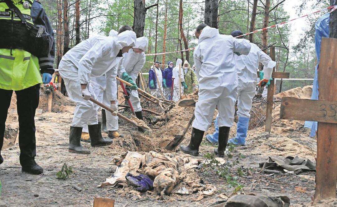 Investigadores desentierran un cuerpo en un bosque cerca de Izyum, en el este de Ucrania. Funcionarios de Kharkiv afirmaron que una fosa común en esta ciudad contenía cientos de cadáveres, al menos 30 con señales visibles de tortura. Foto: SERGEY BOBOK/AP