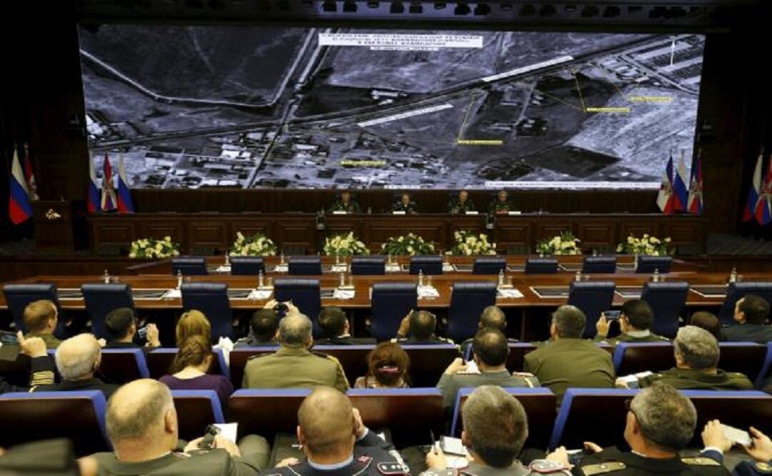 Defense ministry officials sit under screens with satellite images on display during a briefing in Moscow, Russia on December 2, 2015. (Photo: Reuters)