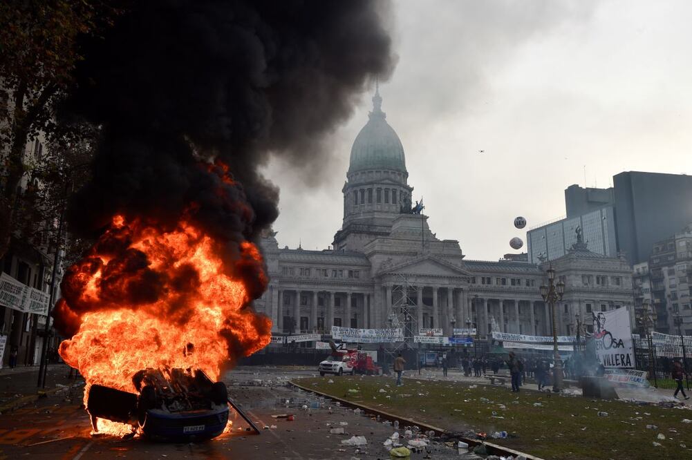 Un automóvil arde durante enfrentamientos entre la policía y manifestantes antigubernamentales frente al Congreso, donde los senadores debaten proyectos de ley promovidos por el presidente argentino Javier Milei. FOTO: AP