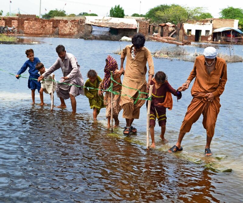 Paquistaníes rodean una zona inundada tras las lluvias en el distrito de Sanghar, provincia de Sindh. Foto: NADEEM KHAWAR. EFE 