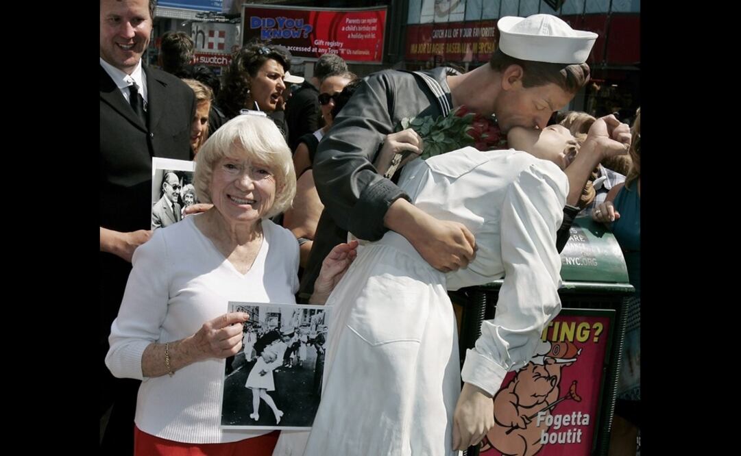 Edith Shain, presunta protagonista de la fotografía "El Beso en Times Square", sujeta la imagen al lado de una estatua. EFE/ Peter Foley, archivo.