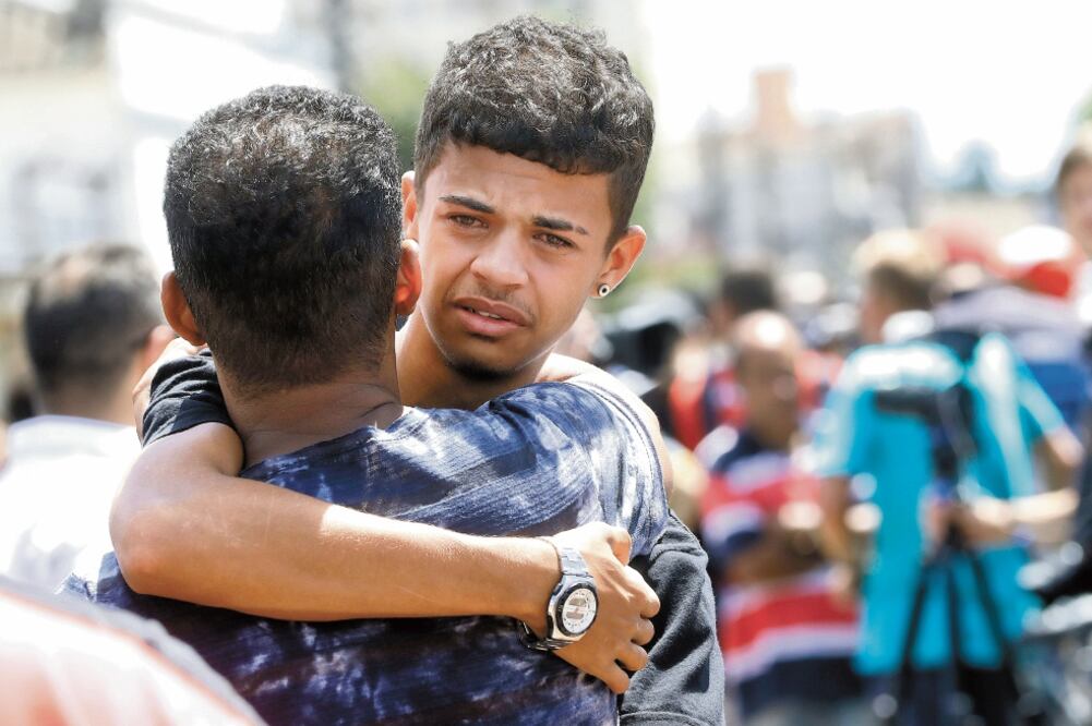 Apoyo. Un exestudiante abraza a un amigo afuera del colegio donde ocurrió el tiroteo, en Sao Paulo. Foto: ANDRE PENNER. AP