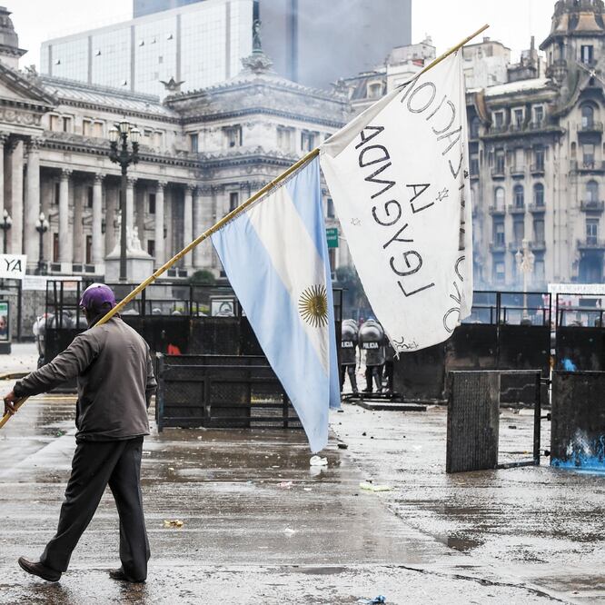 Un manifestante camina frente al Congreso de Argentina, donde los diputados aprobaron ayer el presupuesto de austeridad. (EITAN ABRAMOVICH. AFP)