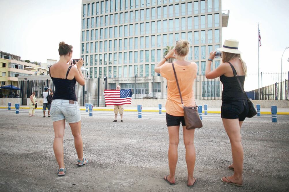 Un ciudadano estadounidense posa con una bandera de su país frente a la nueva embajada de EU en La Habana (ALEXANDRE MENEGHINI. REUTERS)