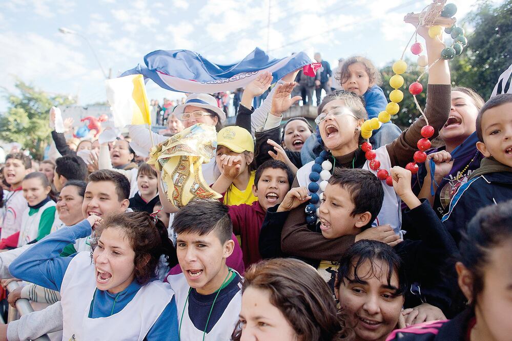 Niños y jóvenes gritan “queremos verte” al papa Francisco, quien pasó frente a ellos en un automóvil. Foto: VÍCTOR R. CAIVANO. AP