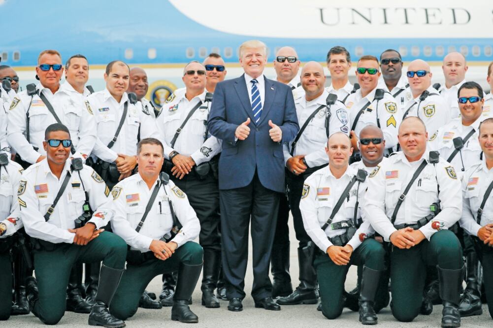 El presidente Donald Trump posa con con un grupo de oficiales antes de abordar el Air Force One para regresar a Washington. (PABLO MARTÍNEZ MONSIVÁIS. AP)