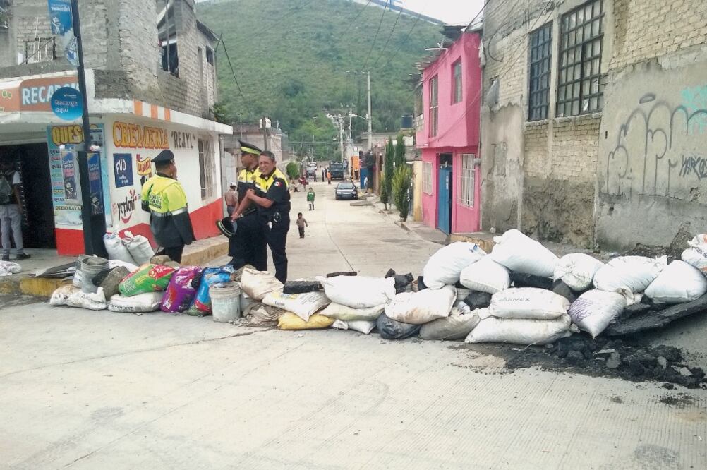 En un intento por detener el avance de las aguas de la presa, vecinos colocaron costales en algunas calles, los cuales no fueron suficientes. (JUAN M. BARRERA. EL UNIVERSAL)