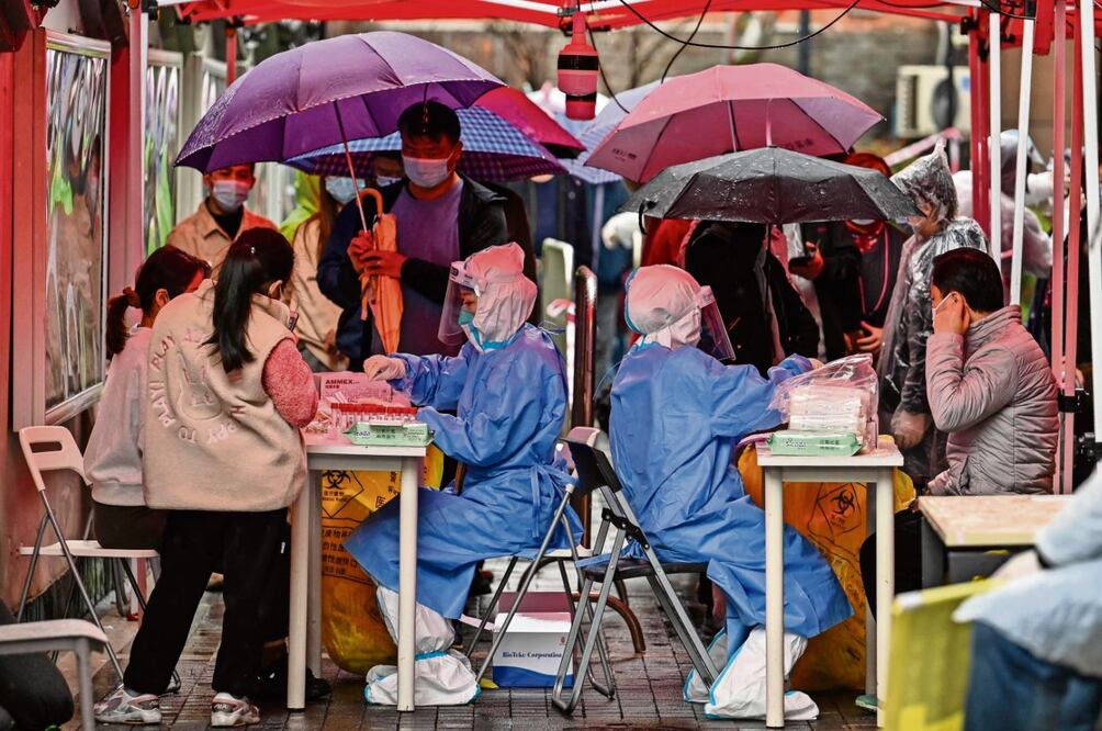 Habitantes de Shanghái se realizan pruebas para detectar el Covid, ante el alza de contagios en el país. Foto: Héctor Retamal/AFP