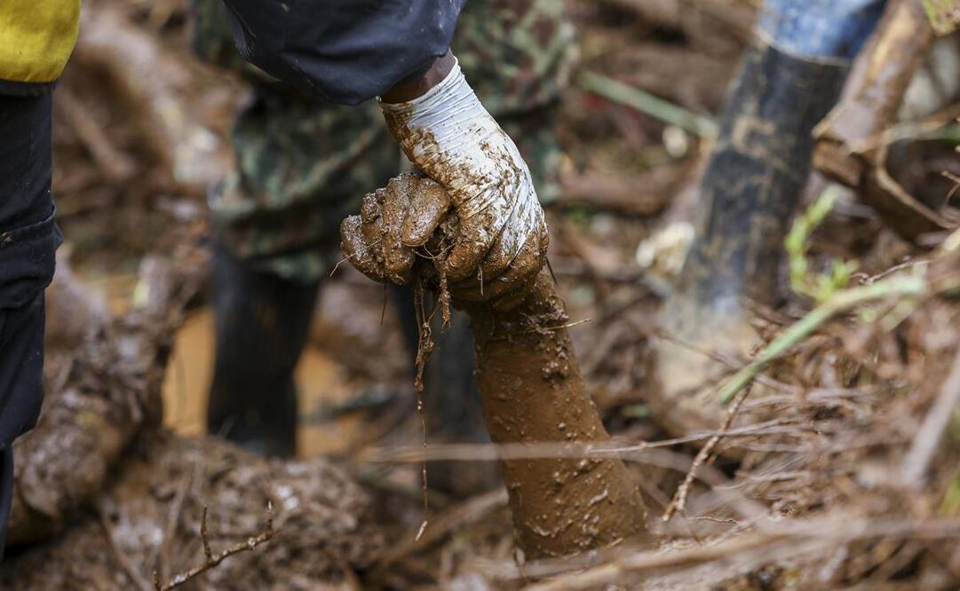 Voluntarios locales y miembros de la Cruz Roja recuperan un cuerpo atrapado bajo el barro durante la operación de rescate en curso después de inundaciones repentinas en la aldea de Kamuchira, en Kenia. Foto: EFE