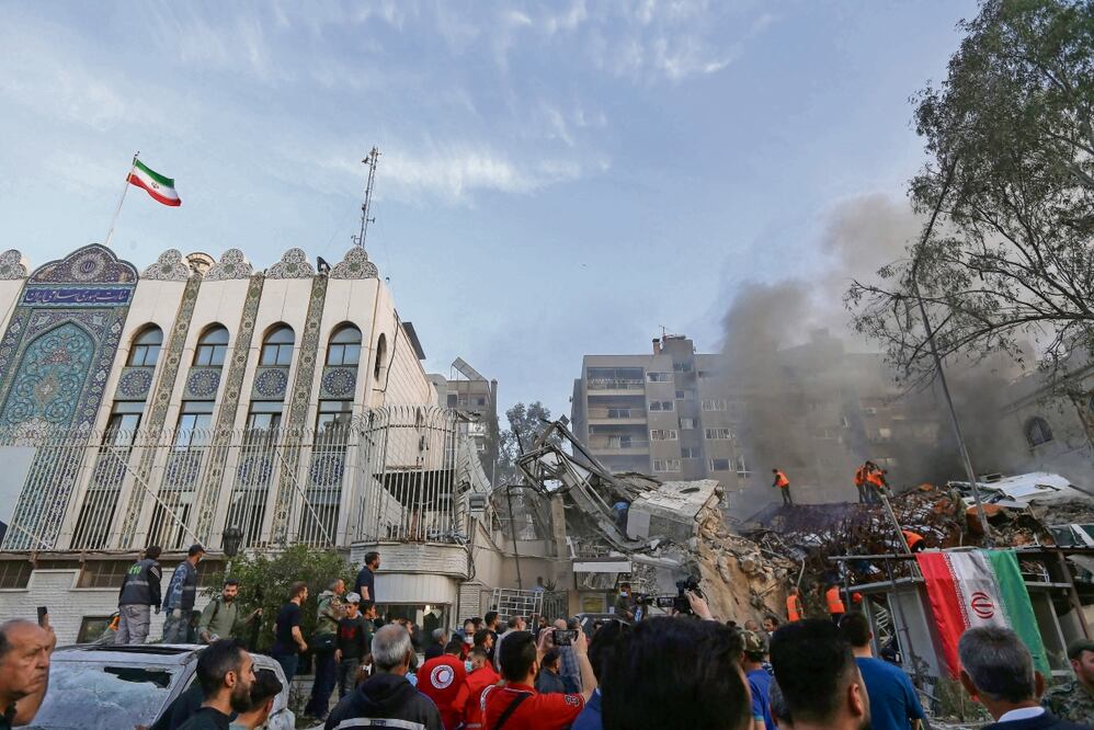 Personal de emergencia y de seguridad busca entre los escombros tras el ataque a un edificio anexo a la embajada iraní en la capital de Siria, Damasco. Foto: AFP