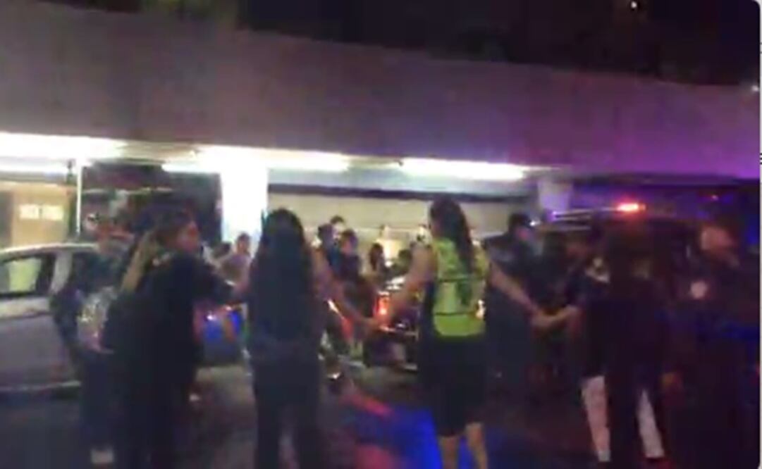 Jóvenes hacen un cerco para rodear a la patrulla donde se encuentra detenida su compañera. Foto: Captura de video