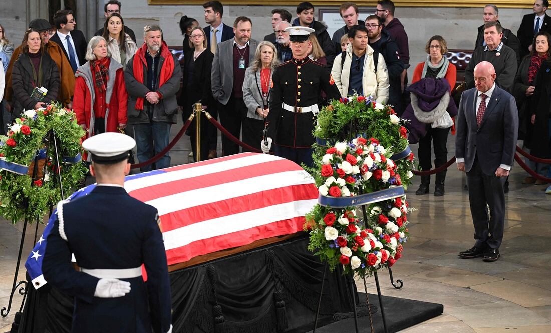 El senador estadounidense Mark Kelly presenta sus respetos ante el féretro envuelto en la bandera durante la ceremonia de entierro del expresidente Jimmy Carter en la rotonda del Capitolio de Estados Unidos en Washington, DC, el 8 de enero de 2025. FOTO: AFP/Archivo