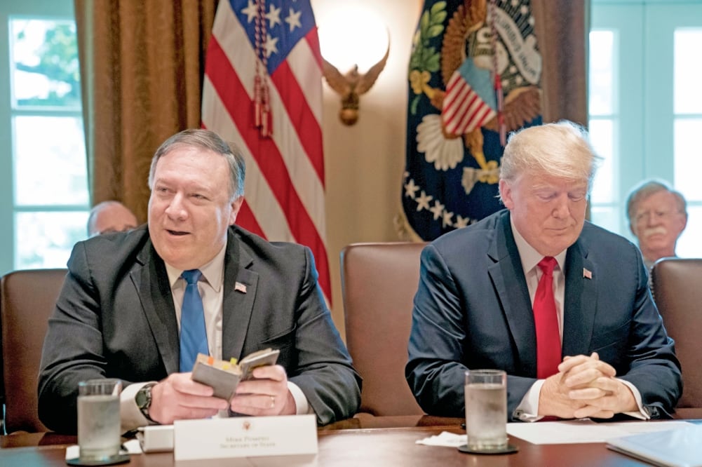 El secretario de Estado, Mike Pompeo (izq.) lee una oración al inicio de la reunión de gabinete en la Casa Blanca, encabezada por el presidente Donald Trump. Foto: ANDREW HARNIK. AP
