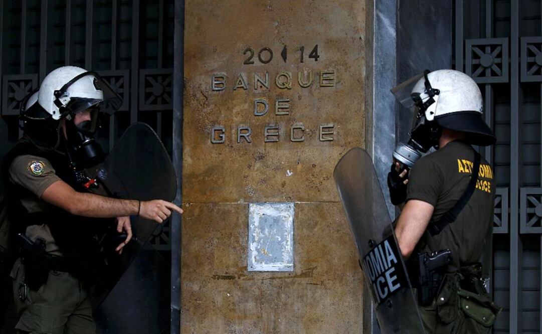 Policías antimotines resguardan la entrada de un banco en Atenas, donde ayer hubo manifestaciones Foto: Reuters