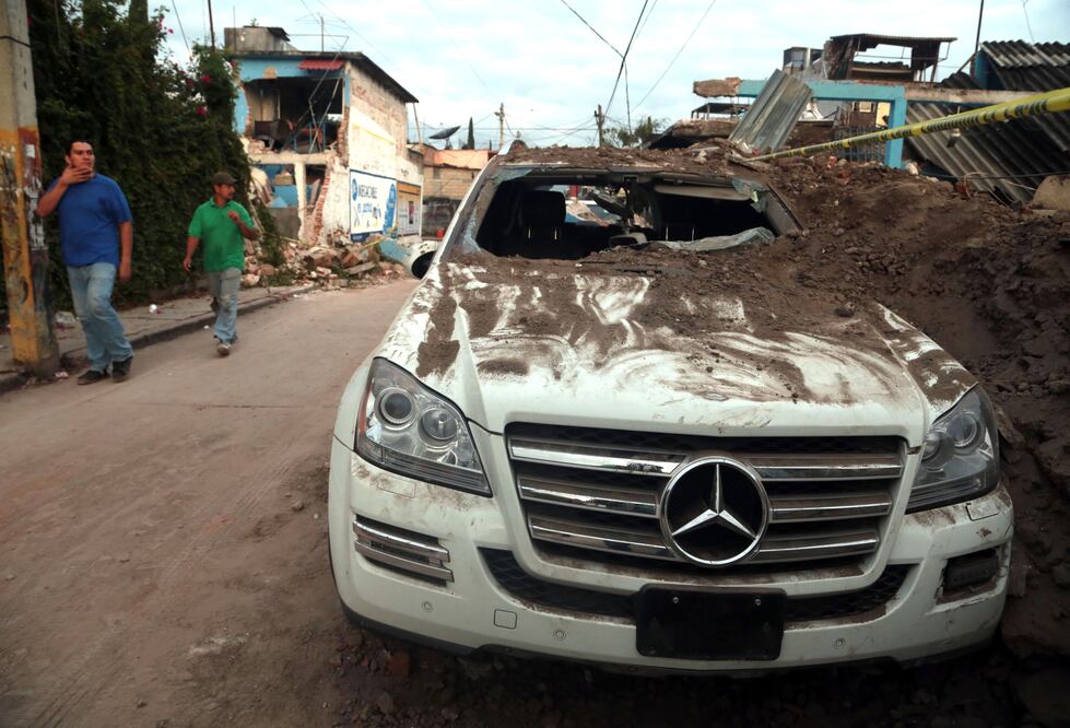 Residentes caminan frente a un automóvil dañado luego del sismo, en Jojutla, en Morelos (Foto: Xinhua) 