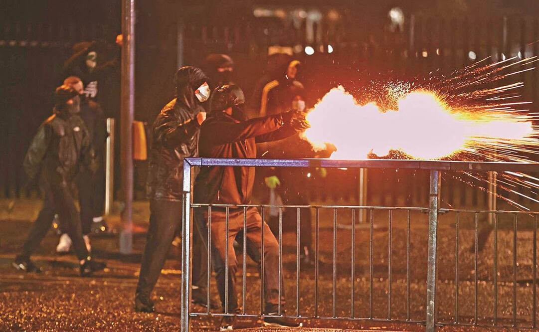 Jóvenes lanzan fuegos artificiales a policías en Belfast, Irlanda del Norte. Desde hace varios días, la zona registra disturbios sin precedente desde hace años. Foto: Liam McBurney/AP.