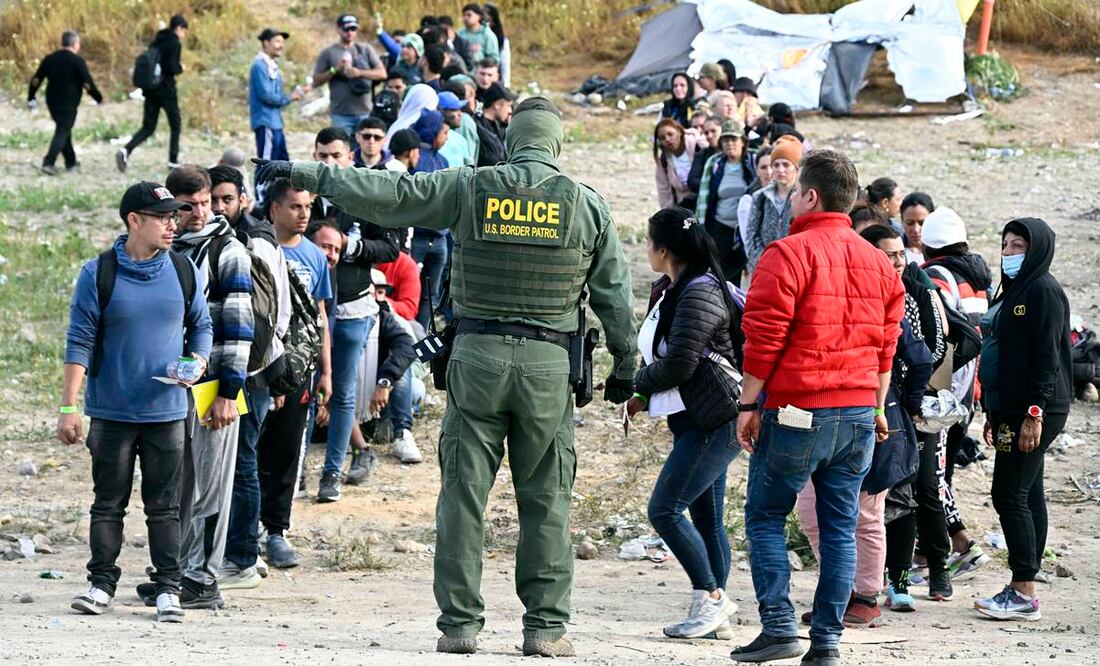 Agente de la Patrulla Fronteriza da indicaciones a solicitantes de asilo para que esperen, cerca de Tijuana. Foto: AP