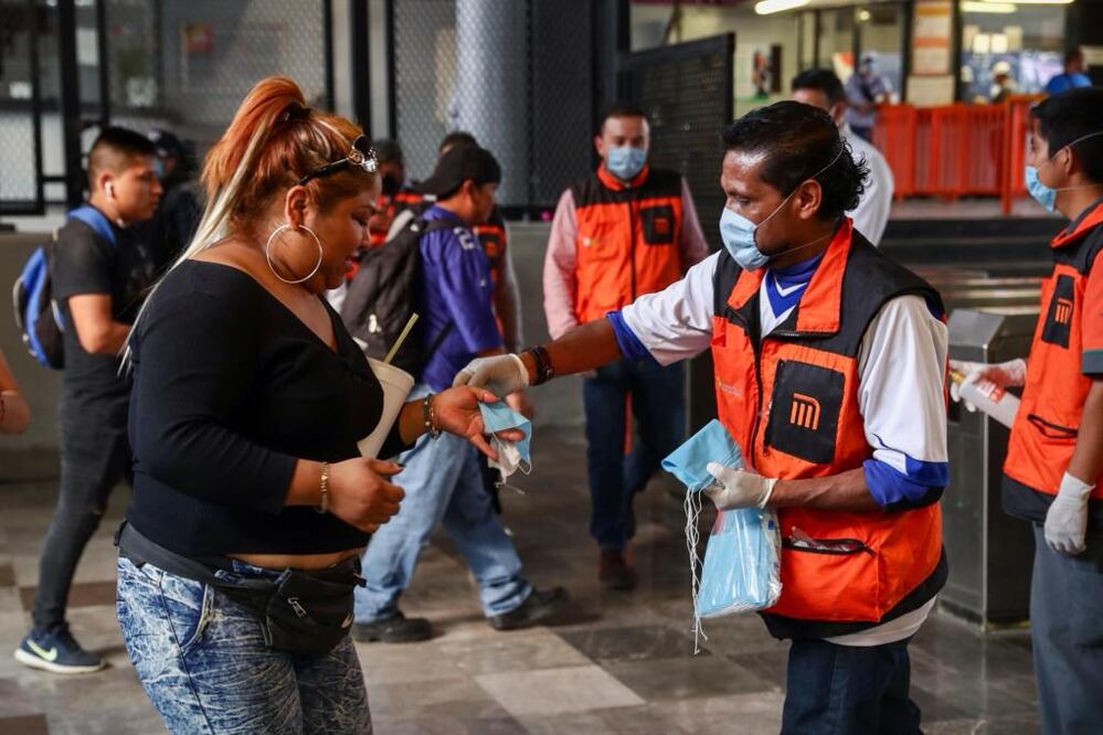 Personal del metro entrega cubrebocas a las personas que utilizan la línea A del metro Pantitlán. FOTOS: DIEGO SIMÓN