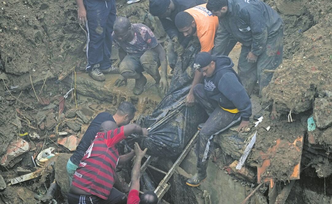 Residentes y voluntarios retiran el cuerpo de una víctima por los aludes en Petrópolis. Foto: Silvia Izquierdo. AP