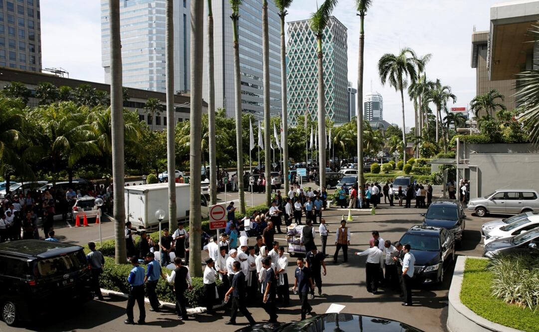 Foto: Varios trabajadores aguardan fuera de un edificio en Yakarta. (EFE)