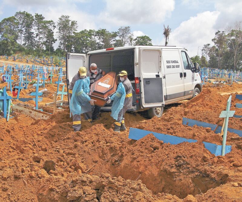 Empleados de un cementerio entierran a una víctima del coronavirus en Manaos. La pandemia está provocando estragos en esta ciudad, la capital del estado de AmazonaS. Foto: EDMAR BARROS. AP