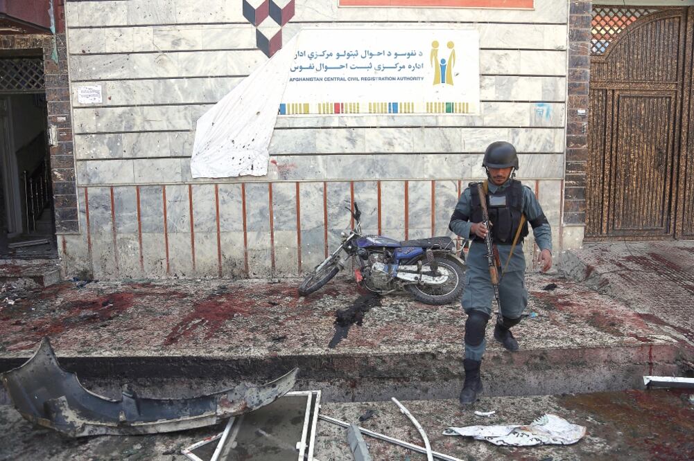 Un policía afgano camina afuera del centro de registro de votantes donde un hombre se inmoló mientras las personas esperaban en la fila; muchas de las víctimas fueron mujeres y niños. Foto: RAHMAT GUL. AP