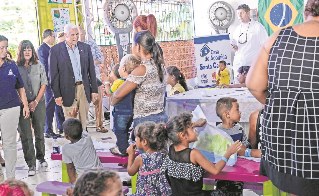 El vicepresidente de Estados Unidos, Mike Pence (de saco) y su esposa Karen saludan a inmigrantes venezolanos, en un albergue en Manaos, Brasil. (RAPHAEL ALVES. EFE)