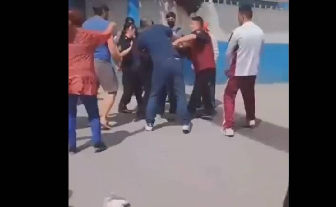 El hombre es confrontado por varias personas, quienes le exigen muestre el rostro al momento en que se lo entregan a los elementos de la Policía Industrial Bancaria / Captura de pantalla