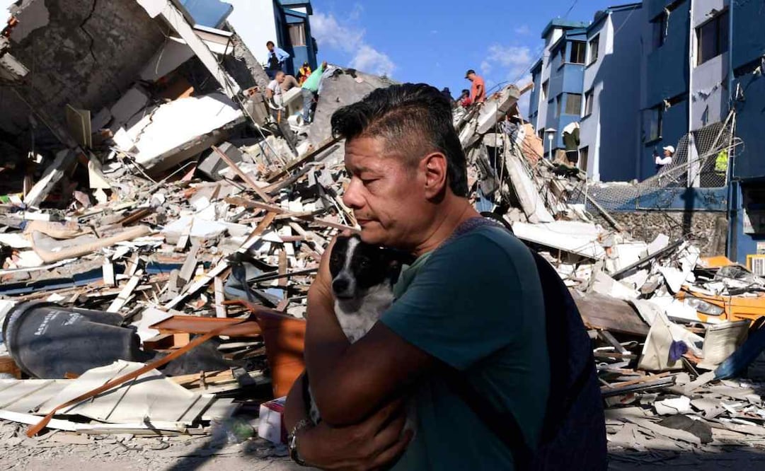 Un hombre con su perrito camina junto a los escombros de un edificio colapsado en la ciudad colombiana de Pereira, tras un terremoto de magnitud 7.4. (10/08/26) Foto: AFP
