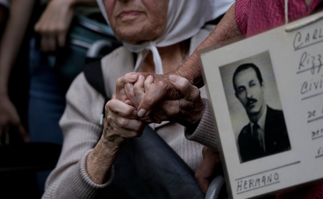 Integrantes del grupo Abuelas de la Plaza de Mayo se sostienen de las manos durante una marcha para conmemorar el aniversario del golpe militar de 1976 en Buenos Aires. Foto: AP
