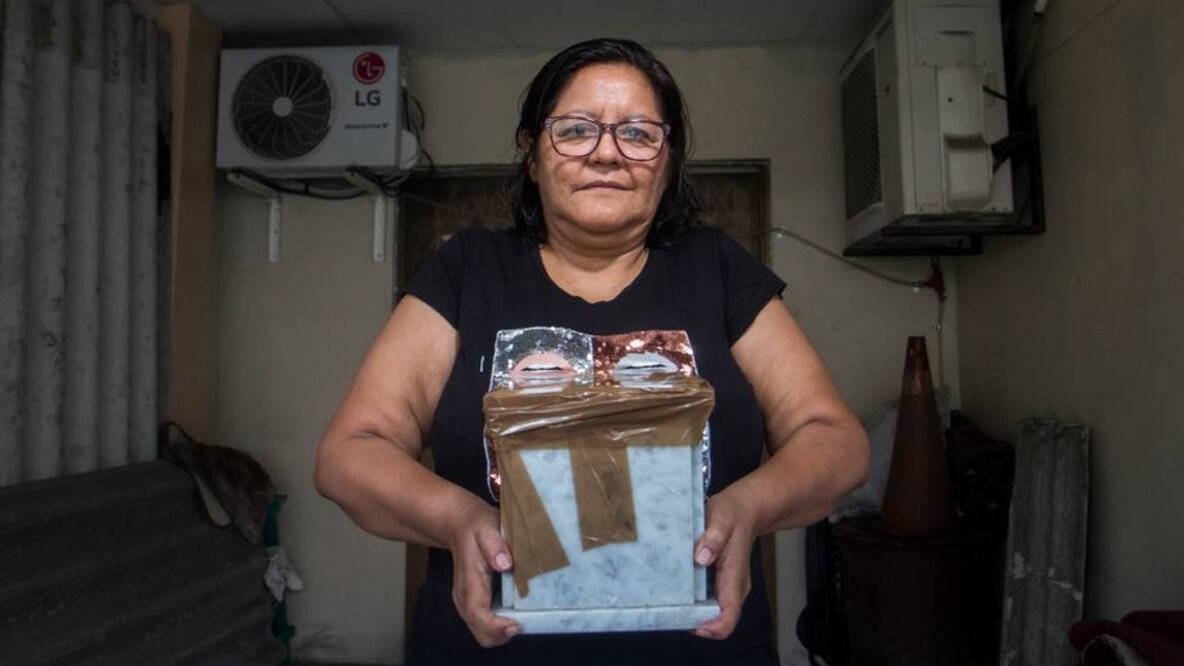 Elsa Maldonado reza a las cenizas que permanecen en esta urna. Son de una víctima de coronavirus a la que nunca conoció. Foto: Cortesía