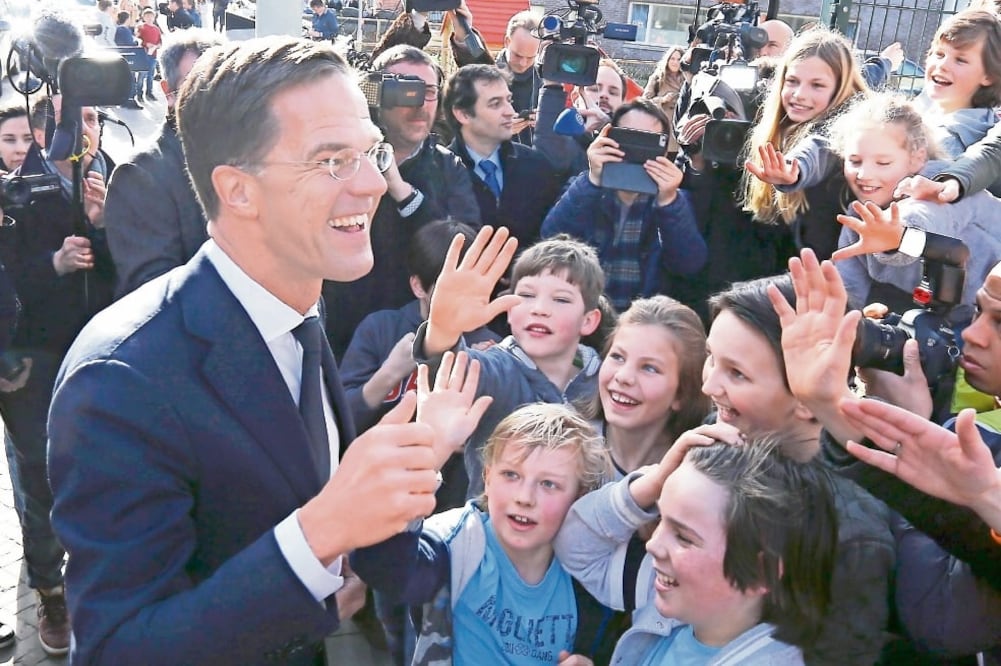 El primer ministro holandés Mark Rutte, del VVD, saluda a simpatizantes después de emitir su voto, en las legislativas en las que quedó en primer sitio (MICHAEL KOOREN. REUTERS)